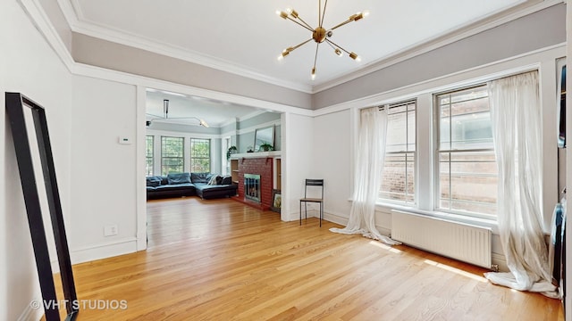 117 S Grove Ave, Oak Park, IL 60302 - living area with radiator, a chandelier, light wood-style floors, crown molding, and a brick fireplace