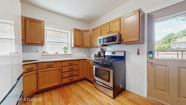 117 S Grove Ave, Oak Park, IL 60302 - kitchen featuring stainless steel appliances, light wood-style flooring, light countertops, backsplash, and brown cabinets