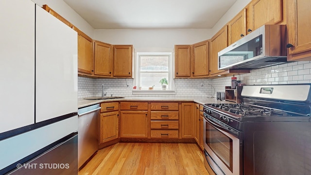 117 S Grove Ave, Oak Park, IL 60302 - kitchen with stainless steel appliances, light wood-style flooring, light countertops, and brown cabinetry