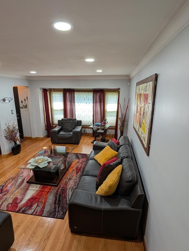living area with recessed lighting, wood finished floors, and crown molding