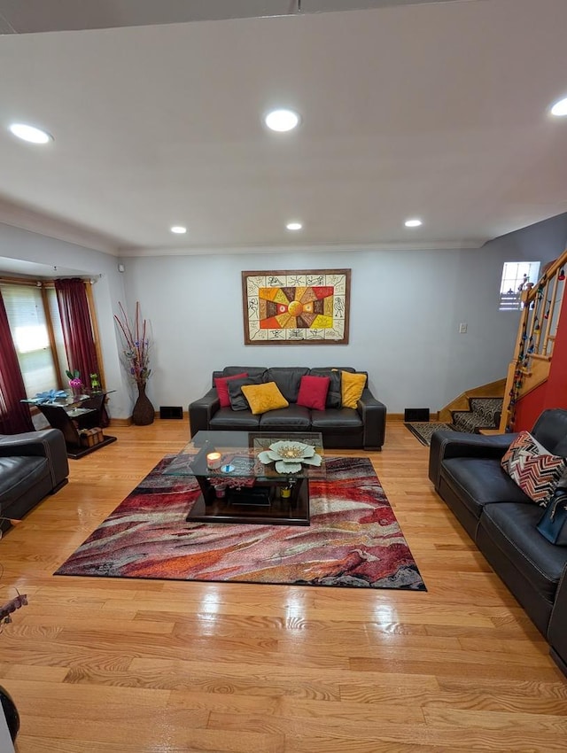 living room featuring recessed lighting, wood finished floors, and stairway
