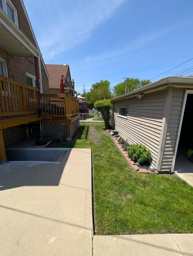 view of green lawn featuring a wooden deck