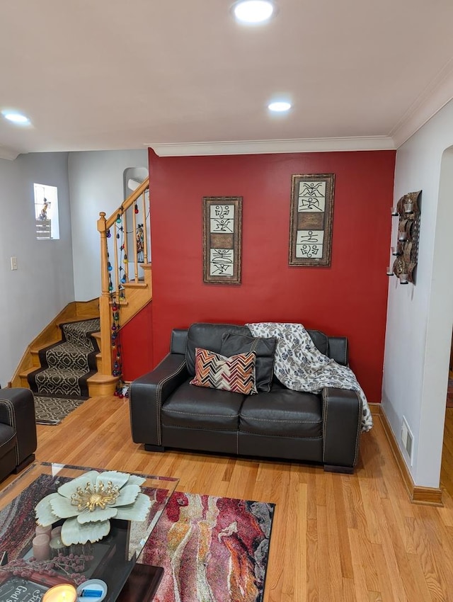 living area with stairway, wood finished floors, ornamental molding, and recessed lighting