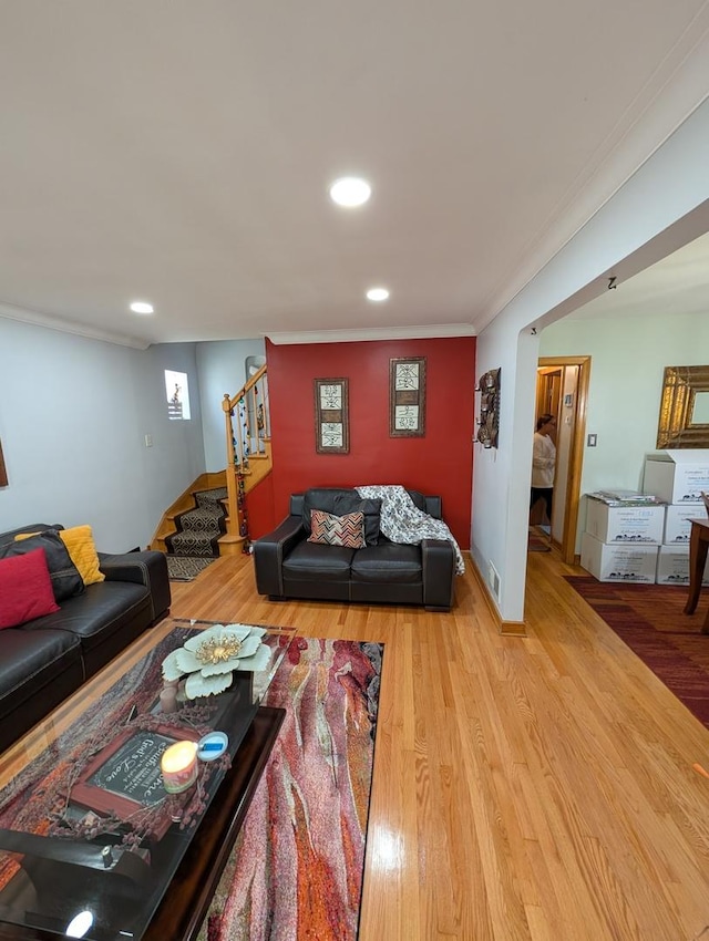 living room featuring stairway, wood finished floors, crown molding, and recessed lighting