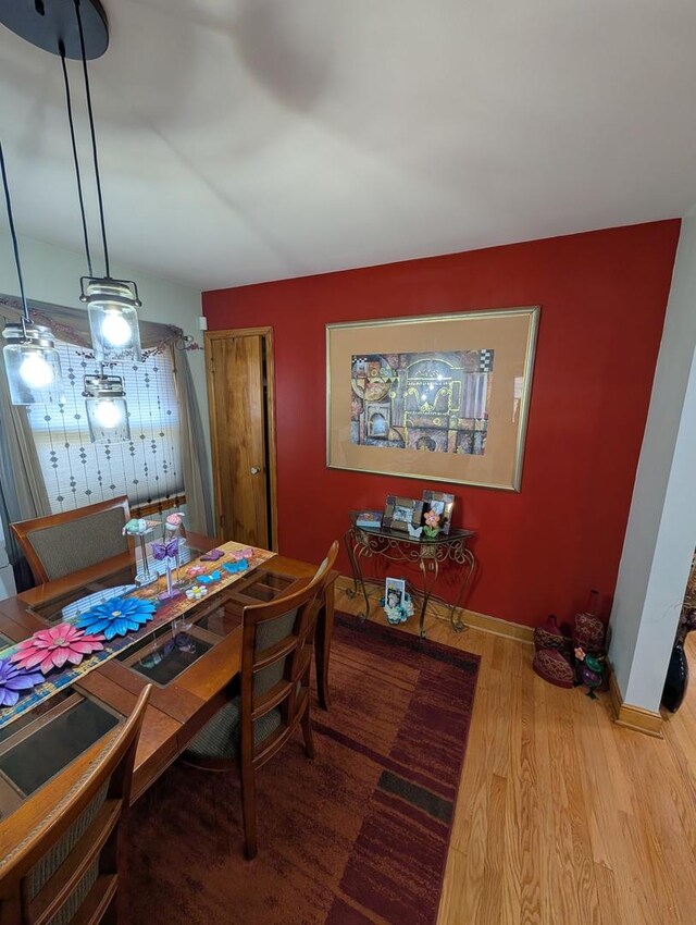 dining space with wood finished floors and baseboards