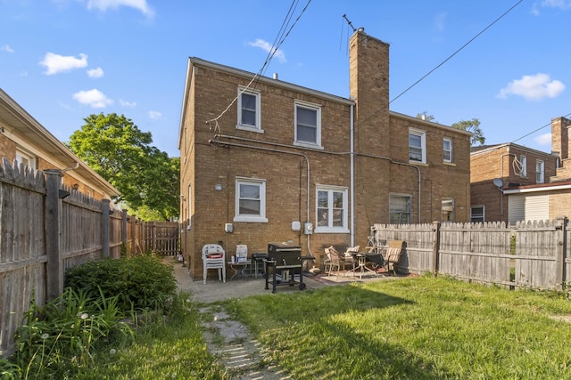 3914 Madison St, Bellwood, IL 60104 - back of house with a fenced backyard, brick siding, a patio area, and a chimney