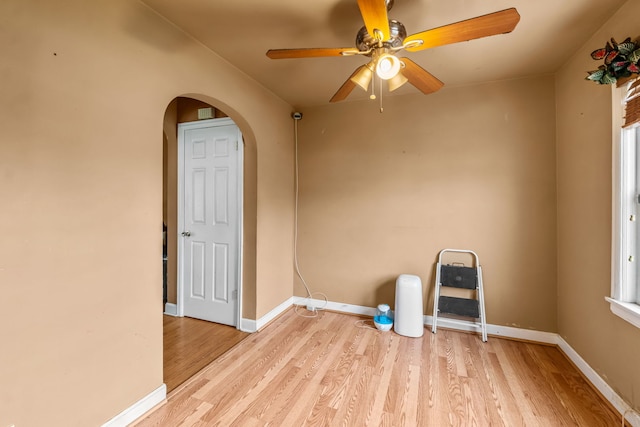 3914 Madison St, Bellwood, IL 60104 - spare room with light wood-style flooring, arched walkways, and ceiling fan