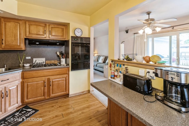 1550 Marshall Dr, Des Plaines, IL 60018 - kitchen featuring black oven, under cabinet range hood, stainless steel gas stovetop, a warming drawer, and light wood-type flooring