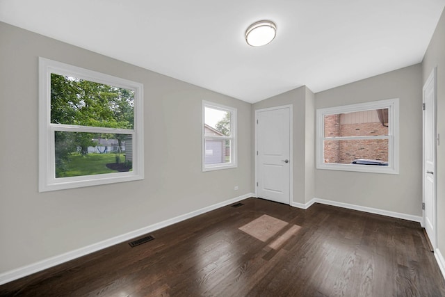 17401 Emerson Ave, Hazel Crest, IL 60429 - unfurnished bedroom with lofted ceiling, multiple windows, and dark wood-style flooring