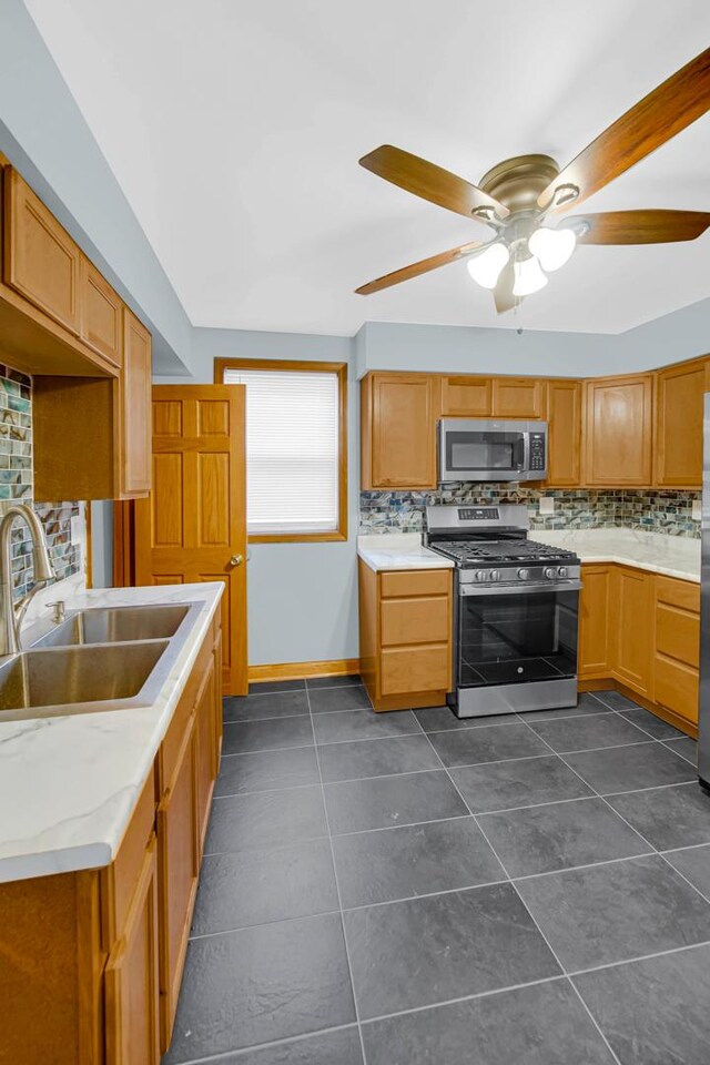 1515 E 85th St, Chicago, IL 60619 - kitchen with appliances with stainless steel finishes, decorative backsplash, a ceiling fan, and light countertops