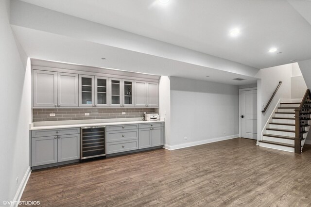 1780 Prairie Ave, Northbrook, IL 60062 - indoor wet bar featuring beverage cooler, wood finished floors, stairway, decorative backsplash, and recessed lighting