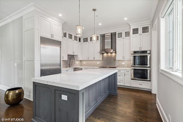 1780 Prairie Ave, Northbrook, IL 60062 - kitchen with wall chimney range hood, stainless steel appliances, white cabinets, tasteful backsplash, and a kitchen island