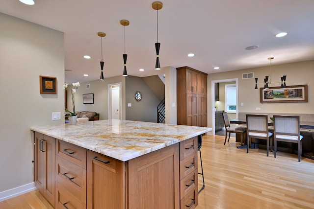 717 S Washington St, Elmhurst, IL 60126 - kitchen featuring light wood-type flooring, decorative light fixtures, light stone counters, recessed lighting, and a peninsula