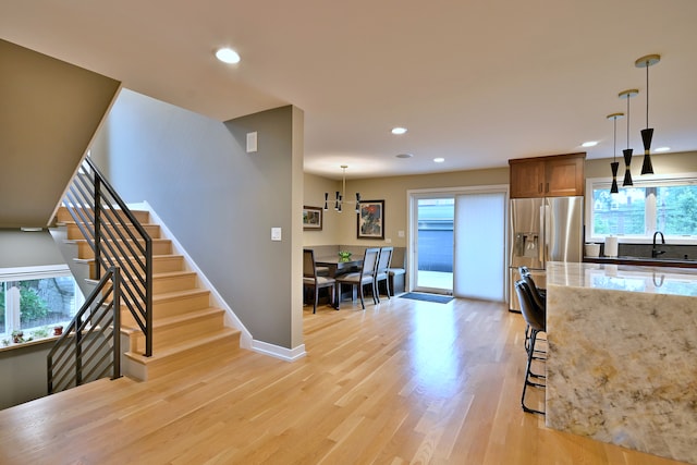 717 S Washington St, Elmhurst, IL 60126 - kitchen featuring stainless steel fridge with ice dispenser, light wood-style floors, light stone countertops, recessed lighting, and pendant lighting
