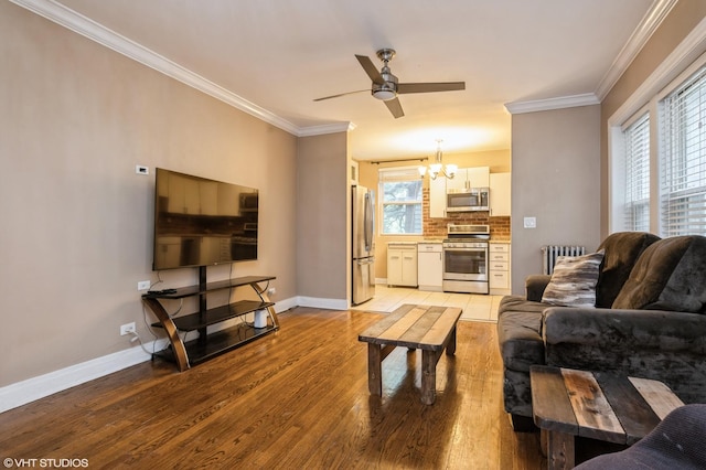 6970 N Wolcott Ave Unit 1, Chicago, IL 60626 - living area featuring a chandelier, radiator heating unit, light wood finished floors, ceiling fan, and ornamental molding