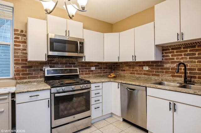6970 N Wolcott Ave Unit 1, Chicago, IL 60626 - kitchen featuring stainless steel appliances, decorative backsplash, light tile patterned floors, and white cabinets