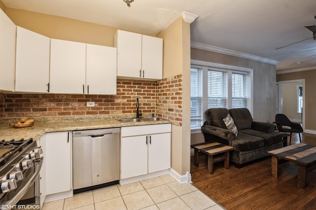 6970 N Wolcott Ave Unit 1, Chicago, IL 60626 - kitchen with appliances with stainless steel finishes, white cabinetry, light tile patterned flooring, crown molding, and decorative backsplash
