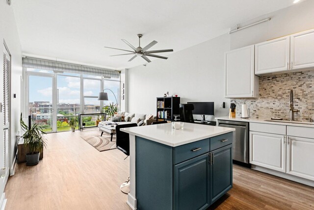 901 W Madison St Unit 1002, Chicago, IL 60607 - kitchen featuring stainless steel dishwasher, backsplash, white cabinets, wood finished floors, and ceiling fan
