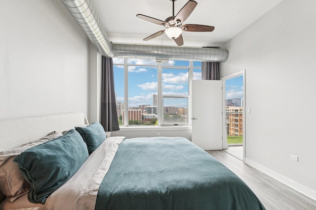 901 W Madison St Unit 1002, Chicago, IL 60607 - bedroom featuring wood finished floors, access to exterior, a view of city, and a ceiling fan