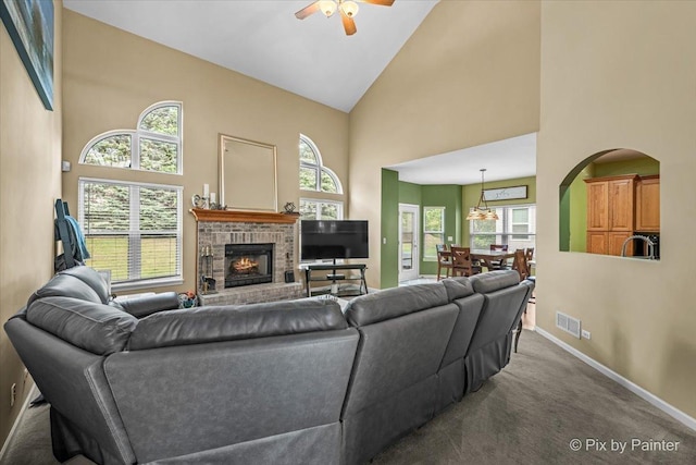 735 Chasewood Dr, South Elgin, IL 60177 - carpeted living area with high vaulted ceiling, a ceiling fan, a brick fireplace, and arched walkways