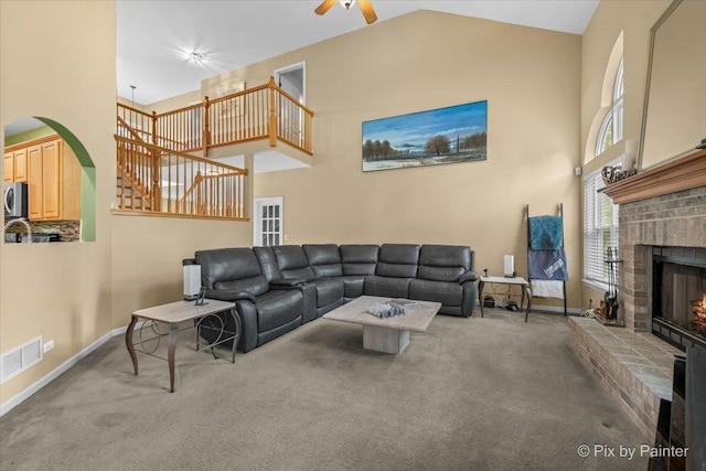 735 Chasewood Dr, South Elgin, IL 60177 - carpeted living area featuring high vaulted ceiling, a fireplace, a ceiling fan, and arched walkways