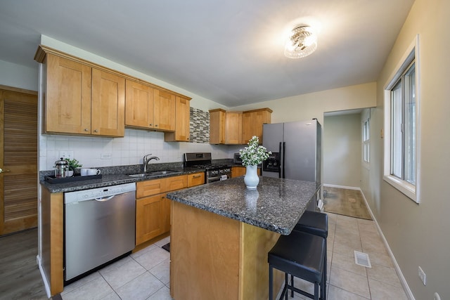 6853 Red Wing Dr, Woodridge, IL 60517 - kitchen with appliances with stainless steel finishes, a breakfast bar, light tile patterned floors, and a kitchen island