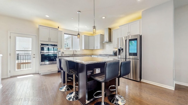 3546 Kemper Dr, Woodridge, IL 60517 - kitchen with appliances with stainless steel finishes, wall chimney range hood, a kitchen island, wood finished floors, and recessed lighting