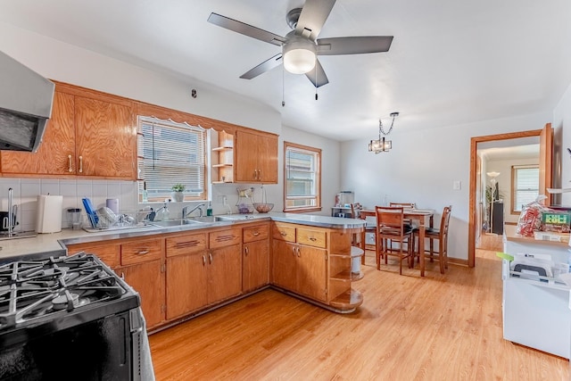 7125 S Richmond St, Chicago, IL 60629 - kitchen with open shelves, exhaust hood, a peninsula, black range with gas stovetop, and tasteful backsplash