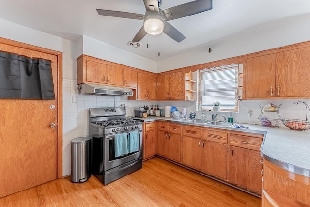 7125 S Richmond St, Chicago, IL 60629 - kitchen featuring stainless steel gas stove, under cabinet range hood, brown cabinetry, ceiling fan, and light wood-style floors