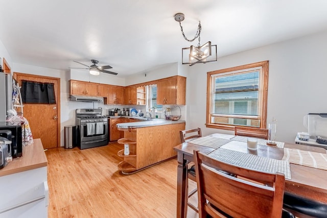 7125 S Richmond St, Chicago, IL 60629 - kitchen featuring gas stove, range hood, brown cabinetry, a peninsula, and a chandelier