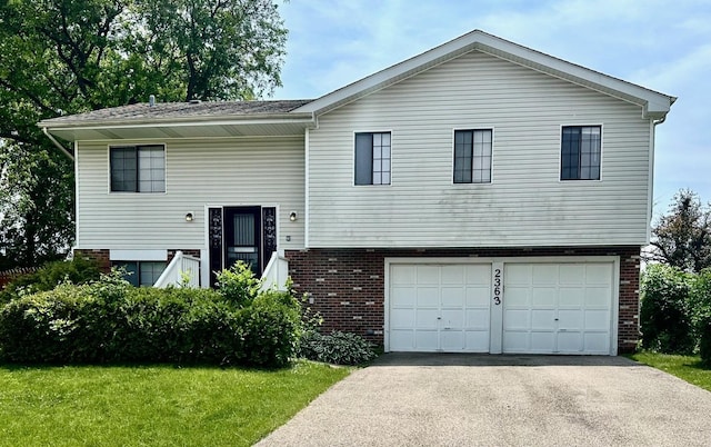 2363 Cove Dr, Hanover Park, IL 60133 - view of front of house with a garage, brick siding, asphalt driveway, and a front yard