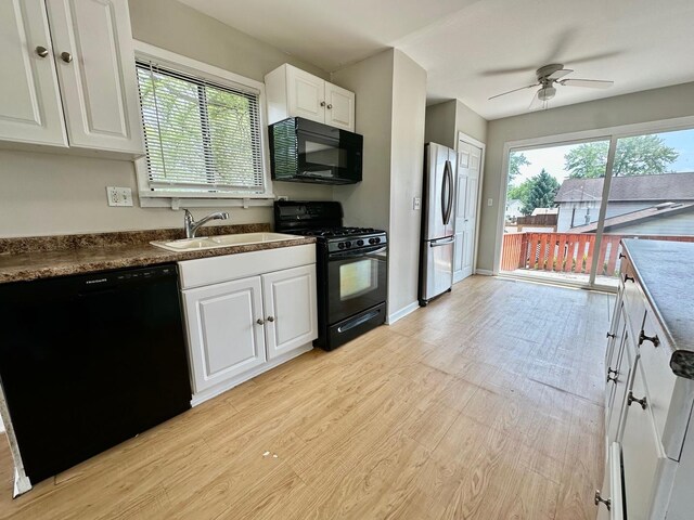 2363 Cove Dr, Hanover Park, IL 60133 - kitchen with black appliances, healthy amount of natural light, light wood-style flooring, and white cabinetry