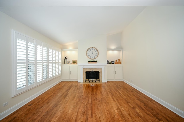 1058 Oakview Dr Unit 1058, Wheaton, IL 60187 - unfurnished living room with lofted ceiling, healthy amount of natural light, wood finished floors, and a tiled fireplace