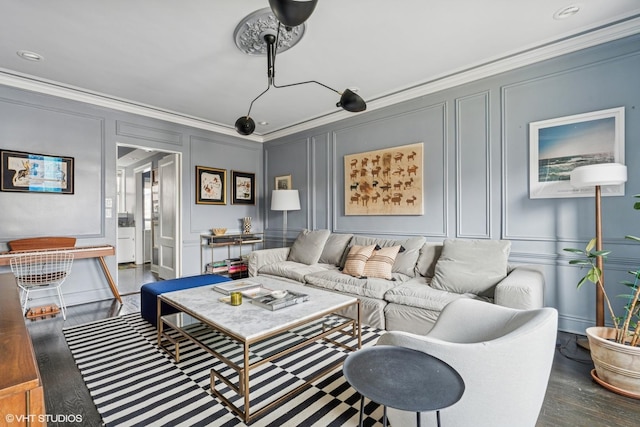 living room featuring a decorative wall, ornamental molding, and wood finished floors