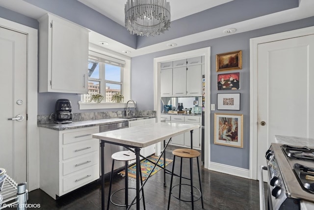 kitchen with stainless steel appliances, white cabinetry, a chandelier, dark wood finished floors, and light countertops