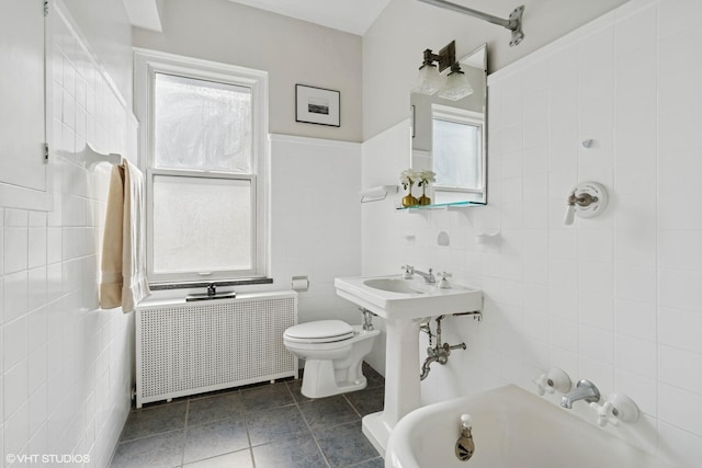 bathroom with tile walls, radiator heating unit, and tile patterned floors