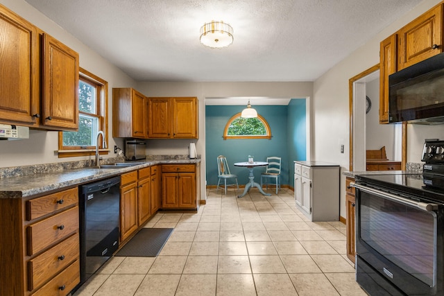 516 E Locust St, Watseka, IL 60970 - kitchen with black appliances, brown cabinetry, dark countertops, a textured ceiling, and light tile patterned flooring