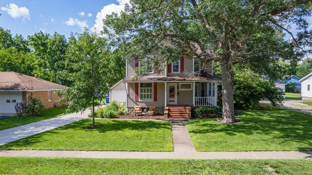 516 E Locust St, Watseka, IL 60970 - view of front of property with covered porch, a front yard, concrete driveway, and a garage