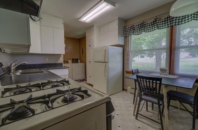 220 N Indiana St, Atwood, IL 61913 - kitchen with white appliances, washer and clothes dryer, white cabinetry, light flooring, and baseboard heating