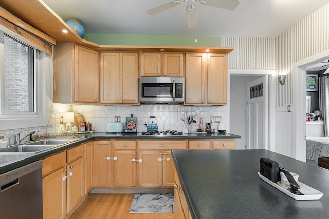 4706 N Paulina St, Chicago, IL 60640 - kitchen with stainless steel appliances, dark countertops, a ceiling fan, and light wood finished floors