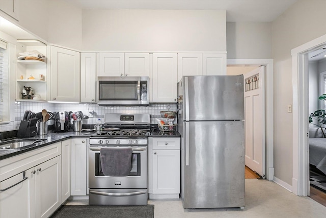 4706 N Paulina St, Chicago, IL 60640 - kitchen featuring stainless steel appliances, backsplash, open shelves, and white cabinets
