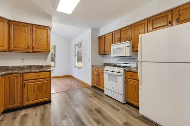 212 Jake Ln, Hampshire, IL 60140 - kitchen with white appliances, dark countertops, vaulted ceiling, brown cabinets, and light wood finished floors