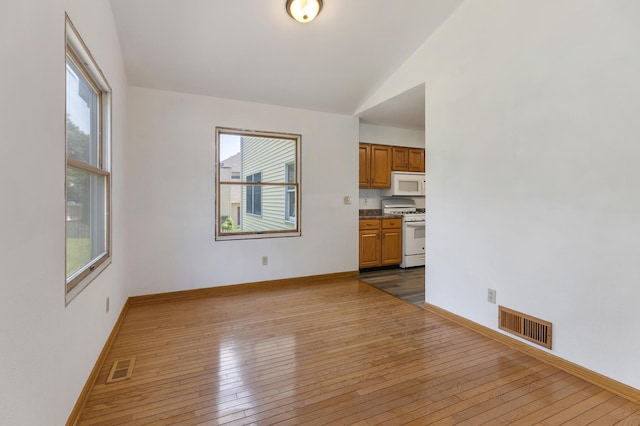 212 Jake Ln, Hampshire, IL 60140 - unfurnished living room with healthy amount of natural light, dark wood-style flooring, and vaulted ceiling