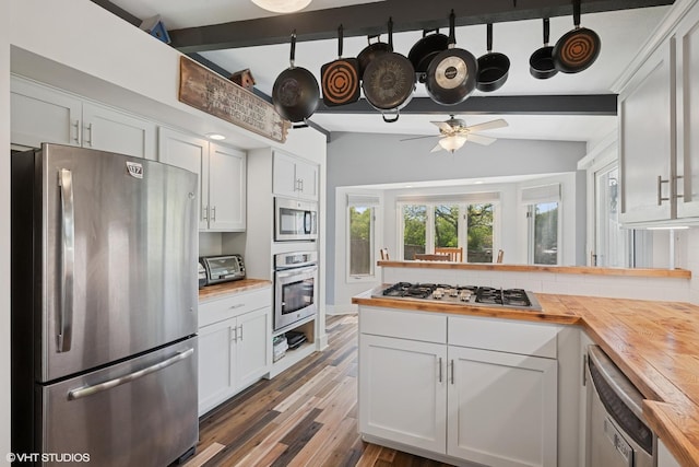 4832 Crest Ct, Waukegan, IL 60087 - kitchen featuring appliances with stainless steel finishes, wooden counters, decorative backsplash, a peninsula, and white cabinetry