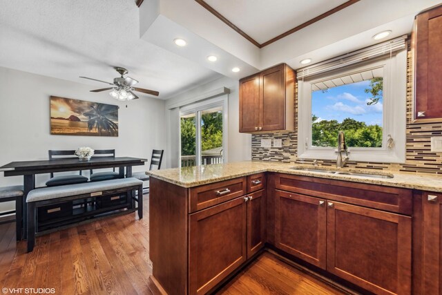 7626 Deerfield Ave, Woodridge, IL 60517 - kitchen featuring decorative backsplash, a peninsula, dark wood-style floors, light stone counters, and ceiling fan