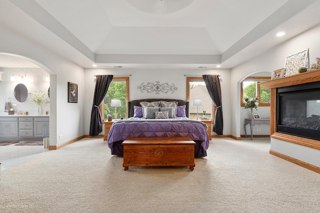 2024 Taller Rd, Morris, IL 60450 - bedroom with a tray ceiling, light carpet, connected bathroom, arched walkways, and recessed lighting