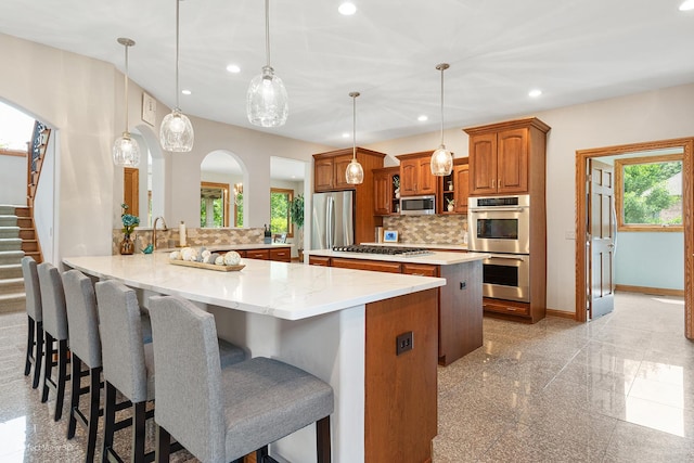 2024 Taller Rd, Morris, IL 60450 - kitchen featuring appliances with stainless steel finishes, brown cabinetry, recessed lighting, a center island, and backsplash