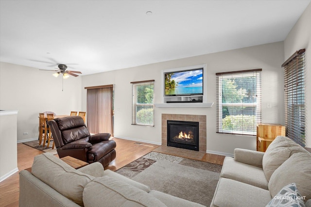 1836 Candlelight Cir Unit 1836, Montgomery, IL 60538 - living area featuring a tile fireplace, wood finished floors, and ceiling fan