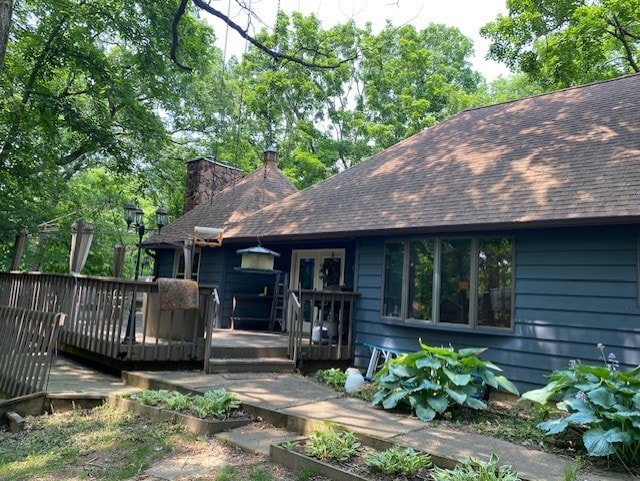 23 Acapulco Dr, Putnam, IL 61560 - back of house featuring a chimney, a wooden deck, a shingled roof, and a vegetable garden