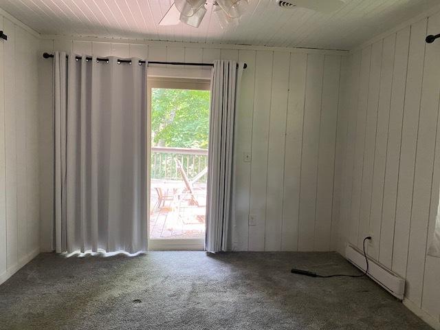 23 Acapulco Dr, Putnam, IL 61560 - unfurnished room featuring a baseboard radiator, carpet floors, ceiling fan, and wooden walls